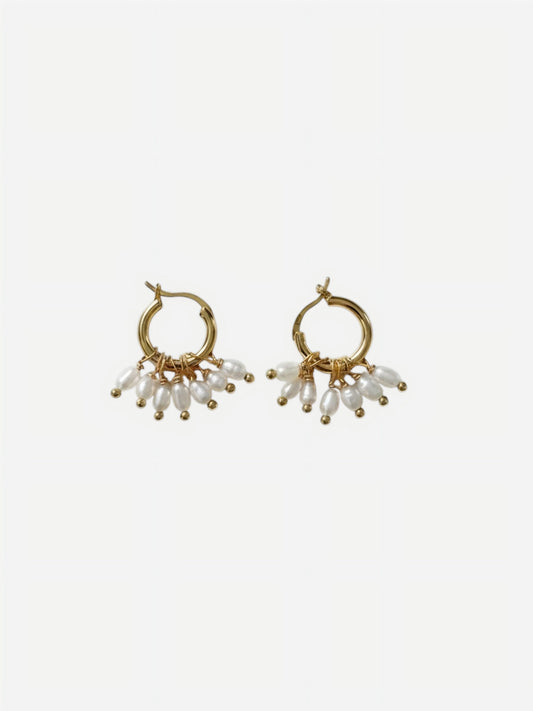 A pair of high-luster, elongated rippled baroque pearl drop earrings suspended from delicate 14K gold-filled hooks against a clean white background. Showcasing minimalist sculptural wedding jewelry.