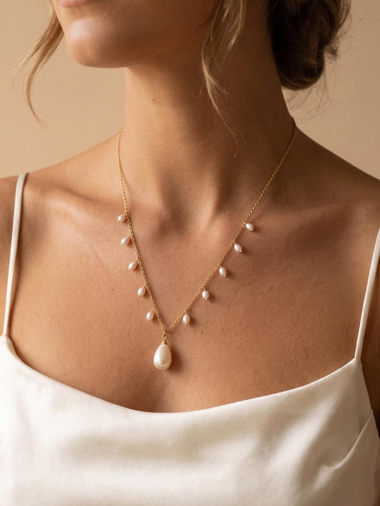 Model with glowing tan skin wearing a multi-pearl shimmer fringe necklace in 14K gold-filled, perfect for clean girl aesthetic and modern bridal accessory.