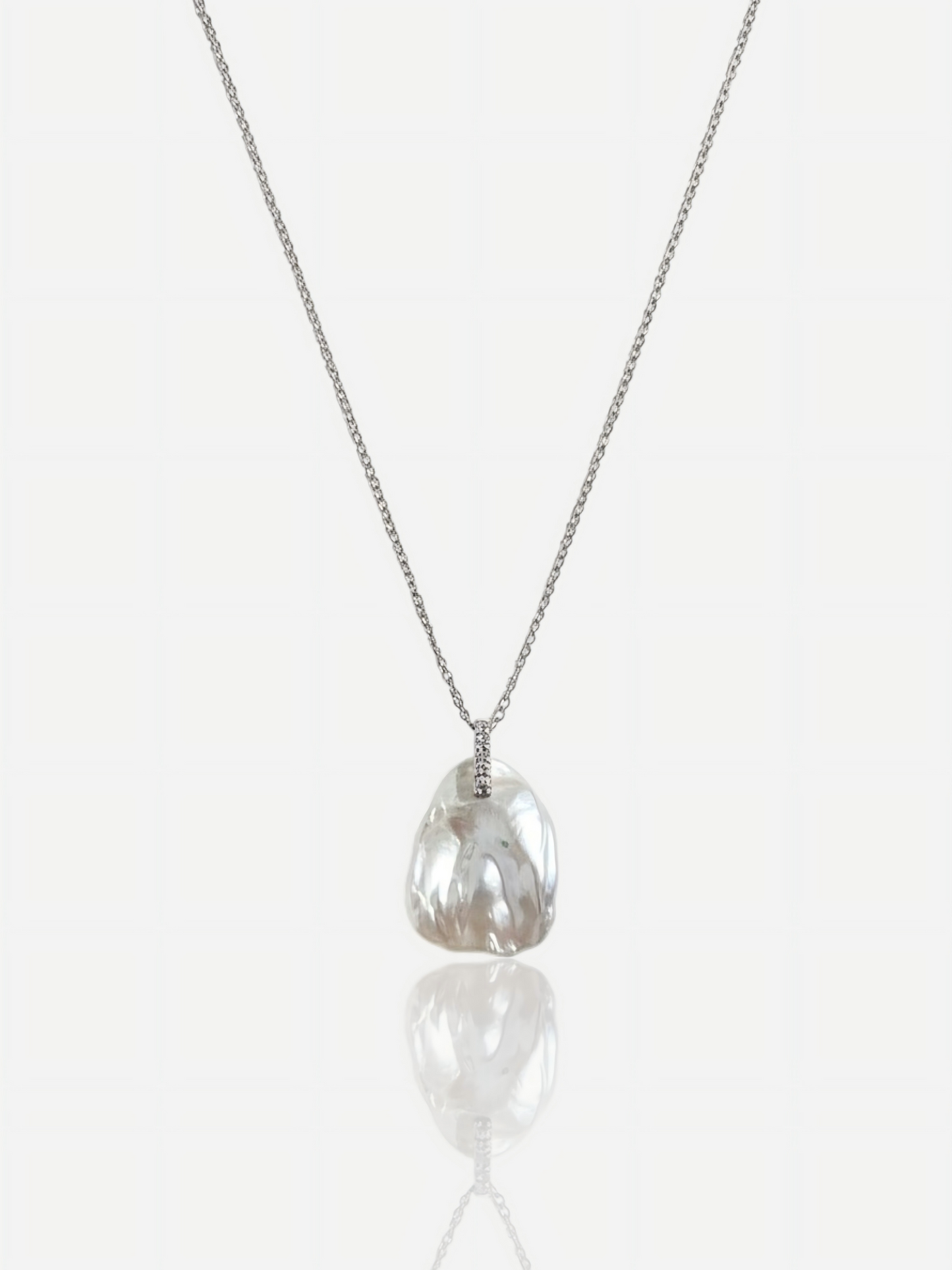 High-luster petal baroque pearl pendant necklace with diamond-accented bail on S925 sterling silver chain, elegant minimalist wedding jewelry for modern brides.