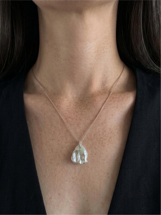 Pearltide minimalist petal baroque pearl necklace with pavé sparkle worn on tan skin, perfect for clean girl aesthetic and modern bridal jewelry.