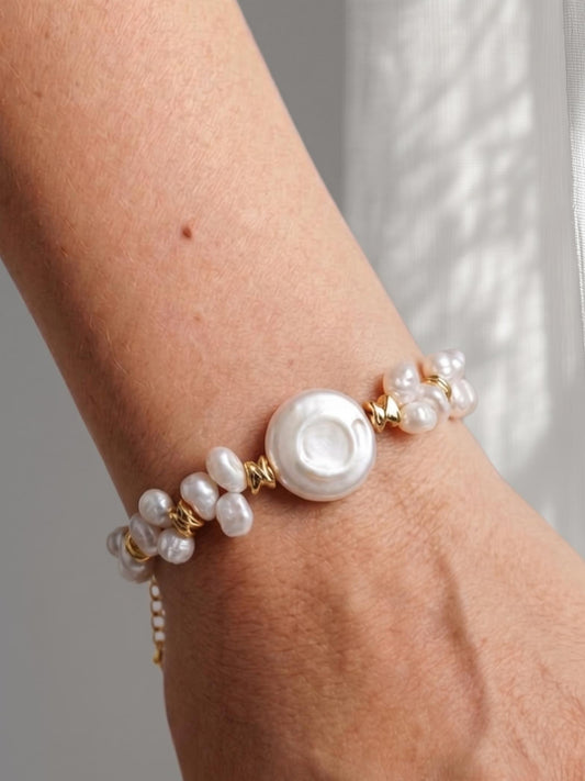 Model with glowing tan skin wearing a Pearltide mixed pearl statement bracelet, perfect for a quiet luxury resort look and sun-kissed vacation aesthetic.