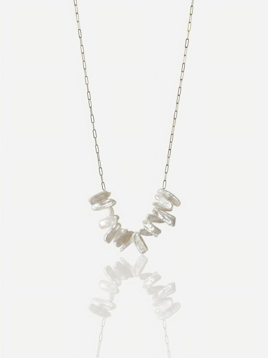 Close-up of Pearltide Lyra necklace featuring high-luster irregular stick pearls on a dainty gold paperclip chain, minimalist organic jewelry on a white background.