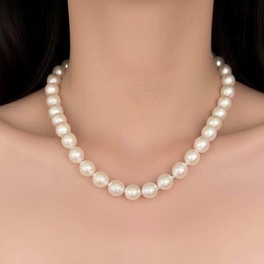 A model wearing a large Edison pearl pendant necklace, highlighting its size and metallic shine against the skin.