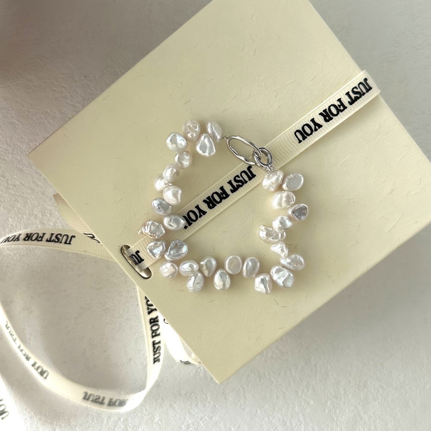 Close-up detail of irregular freshwater pearls woven into a cluster formation, showing the silver clasp and high-luster surface texture.