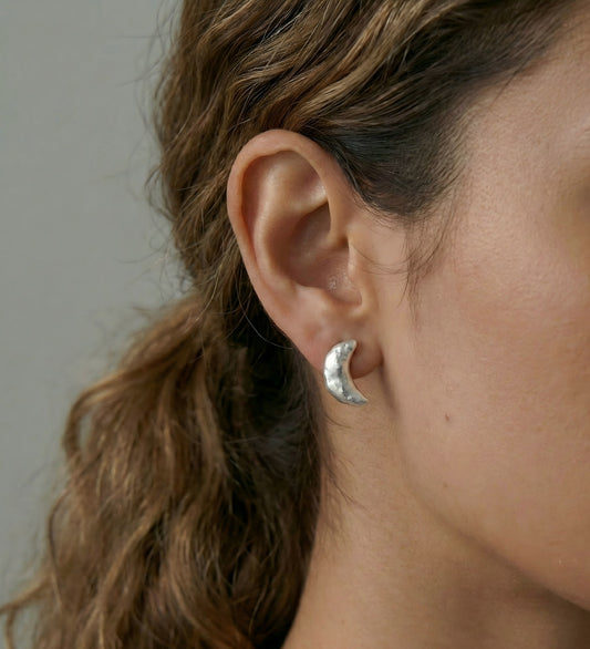 Model wearing dainty crescent moon pearl studs, styling a celestial jewelry look.