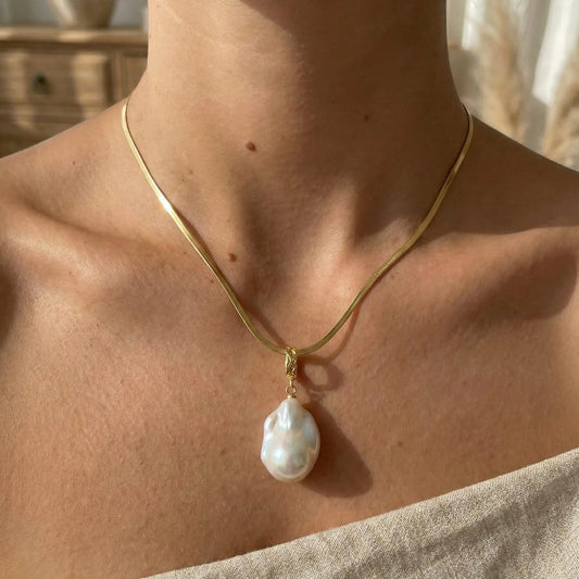 A model wearing the gold vintage flat chain necklace, showing how the herringbone style lays flat against the collarbone.