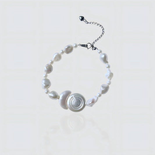 A clean view showing the unique asymmetry of mixed baroque pearls surrounding the central geometric shell motif, finished with silver hardware.