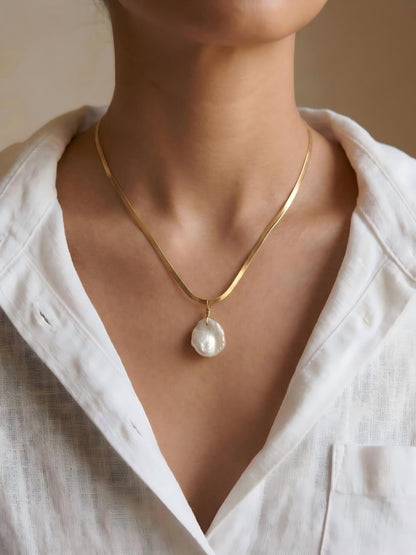 Woman wearing a white linen shirt styled with a gold baroque pearl pendant necklace, effortless elegance jewelry
