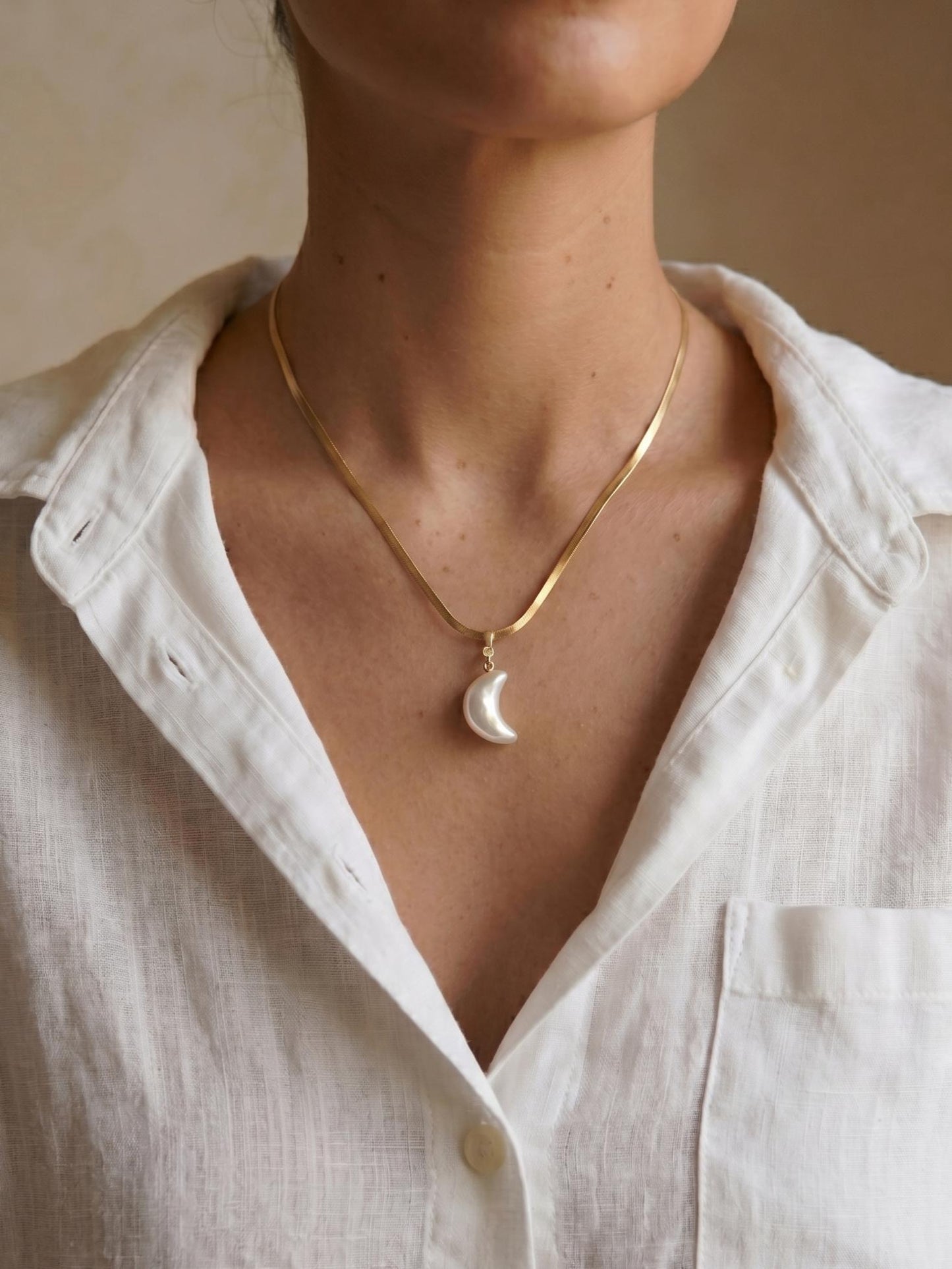 Pearltide Azure Crush crescent moon pearl necklace, with a unique crushed-texture pearl and a small diamond stud. 