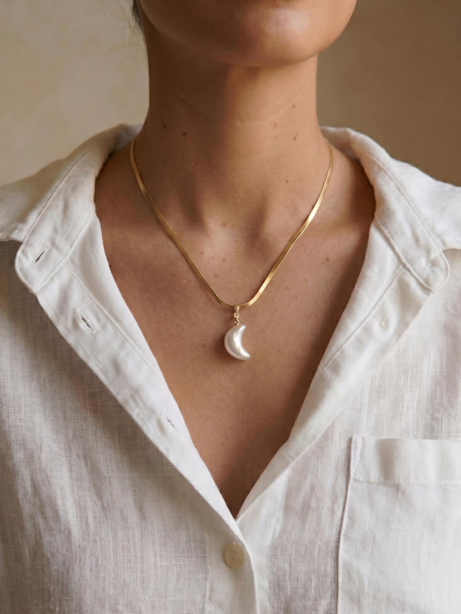 Pearltide Azure Crush crescent moon pearl necklace, with a unique crushed-texture pearl and a small diamond stud. 