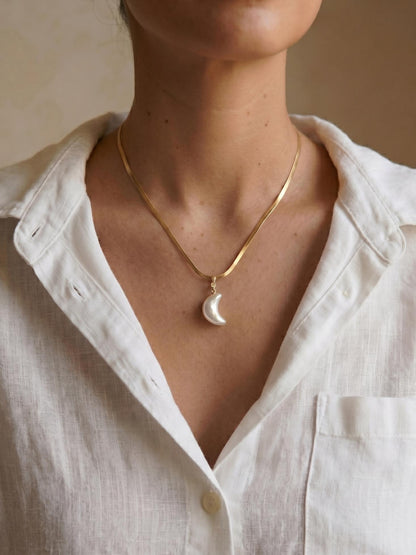 Pearltide Azure Crush crescent moon pearl necklace, with a unique crushed-texture pearl and a small diamond stud. 