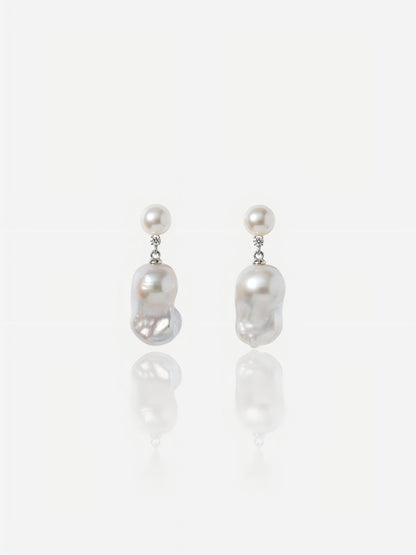 Close-up of Pearltide Celeste petite baroque pearl jewelry earrings featuring small round pearl studs, brilliant cubic zirconia links, and dainty organic drops on a white reflective background, elegant minimalist pearl jewelry.