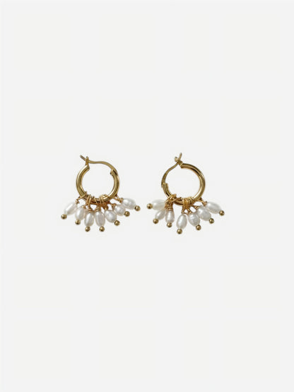 A pair of high-luster, elongated rippled baroque pearl drop earrings suspended from delicate 14K gold-filled hooks against a clean white background. Showcasing minimalist sculptural wedding jewelry.