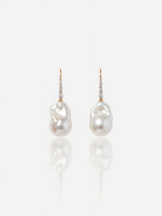 Close-up of Pearltide Elara sculptural gold pearl jewelry earrings featuring textured molten 18K gold plates and flawless round pearls on a white reflective background, elegant quiet luxury jewelry.