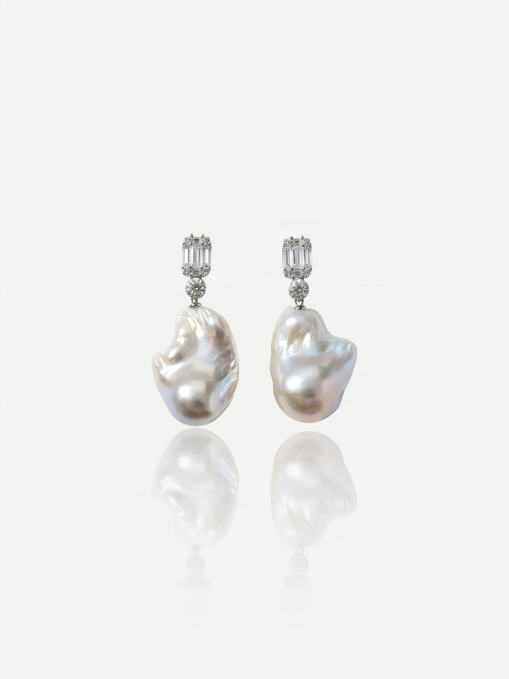 Close-up of Pearltide Lumina geometric baroque pearl jewelry earrings featuring emerald-cut cubic zirconia studs and massive organic pearls on a white reflective background, elegant modern bridal pearl jewelry.