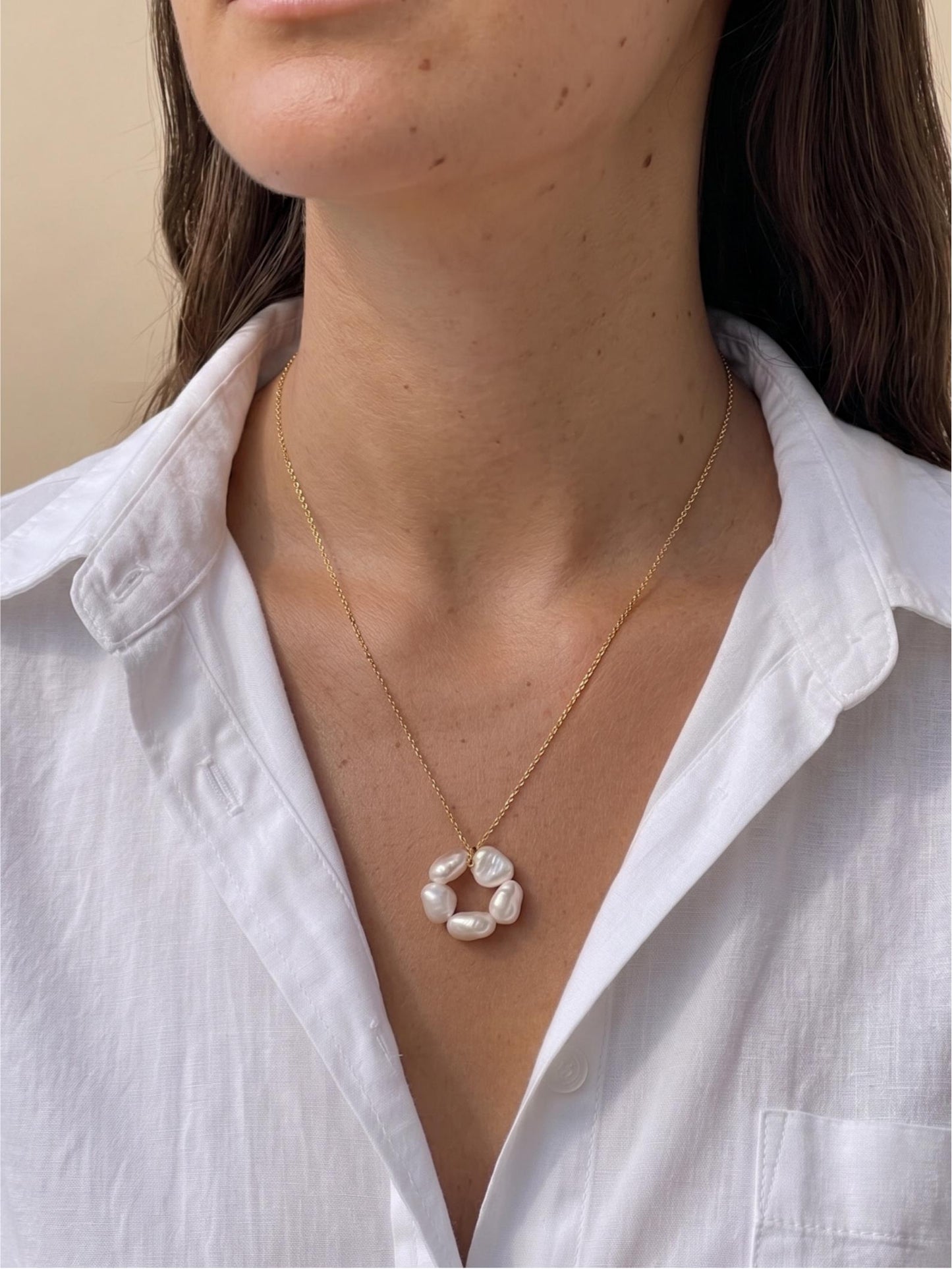 Model with sunkissed tan skin wearing Pearltide’s large sculptural petal baroque pearl statement necklace with a crisp white shirt. Perfect for clean girl aesthetic everyday luxury and modern bridal style.