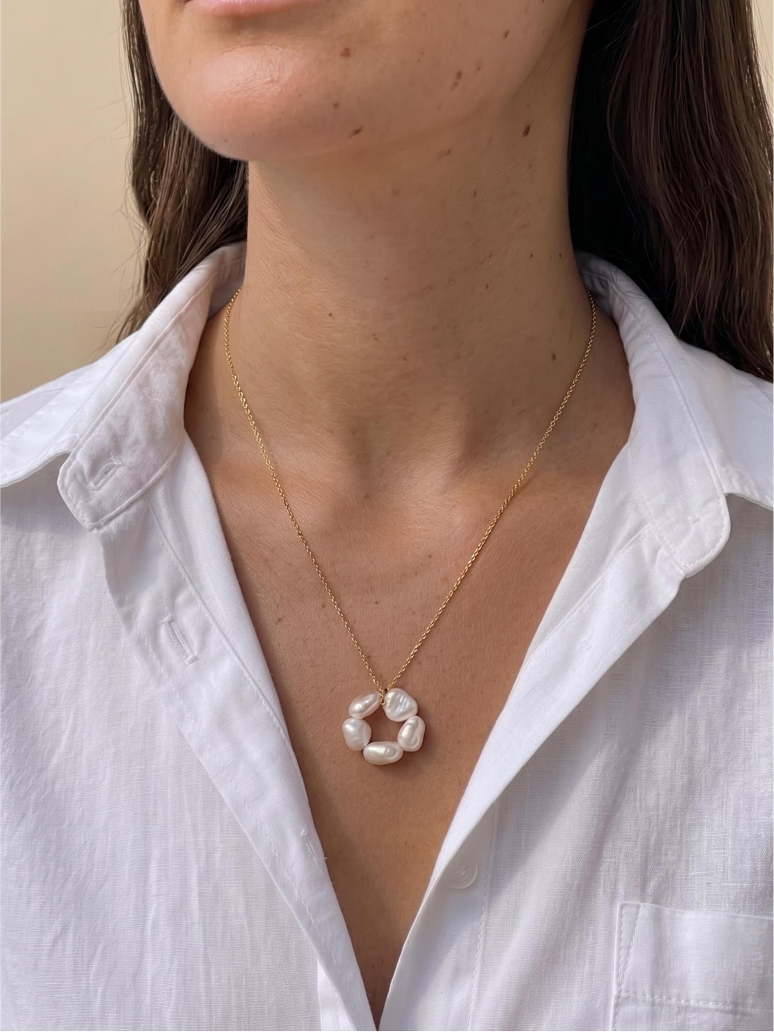 Model with sunkissed tan skin wearing Pearltide’s large sculptural petal baroque pearl statement necklace with a crisp white shirt. Perfect for clean girl aesthetic everyday luxury and modern bridal style.