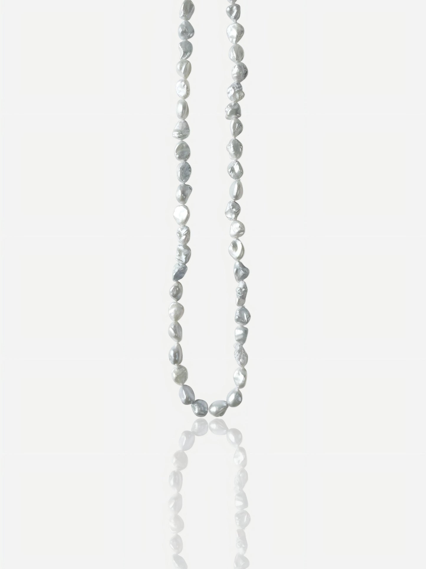 Macro close-up of Pearltide "Blue Blood" crushed silver Keshi pearl necklace with icy metallic luster on an S925 sterling silver chain, minimalist organic resort jewelry for a modern sun-kissed look.