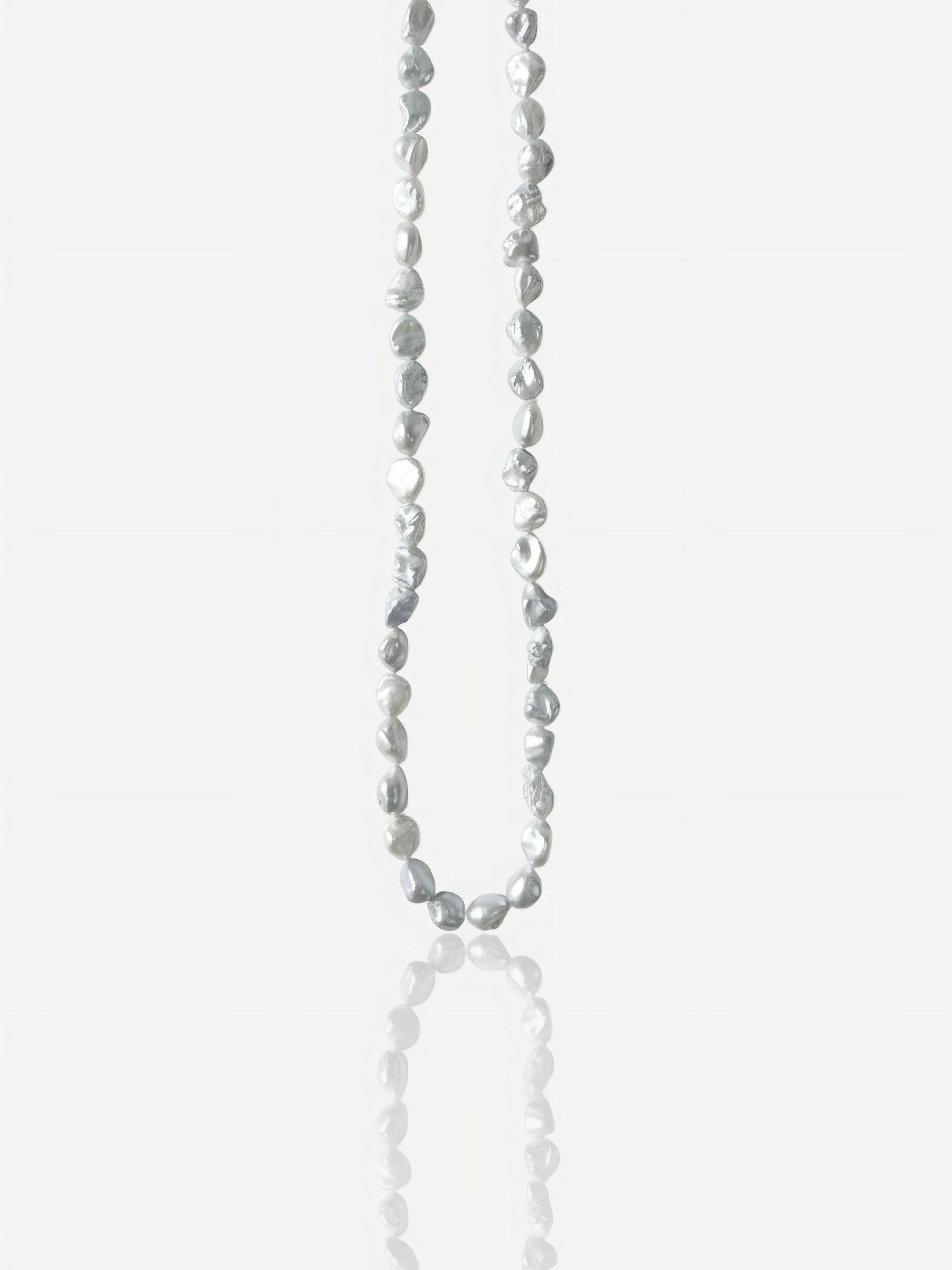 Macro close-up of Pearltide "Blue Blood" crushed silver Keshi pearl necklace with icy metallic luster on an S925 sterling silver chain, minimalist organic resort jewelry for a modern sun-kissed look.