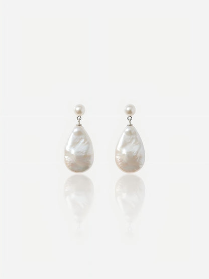 Close-up of Pearltide Odessa teardrop baroque pearl jewelry earrings featuring small round pearl studs and large pear-shaped waterdrop pearls on an S925 sterling silver setting against a white reflective background, elegant quiet luxury bridal jewelry.