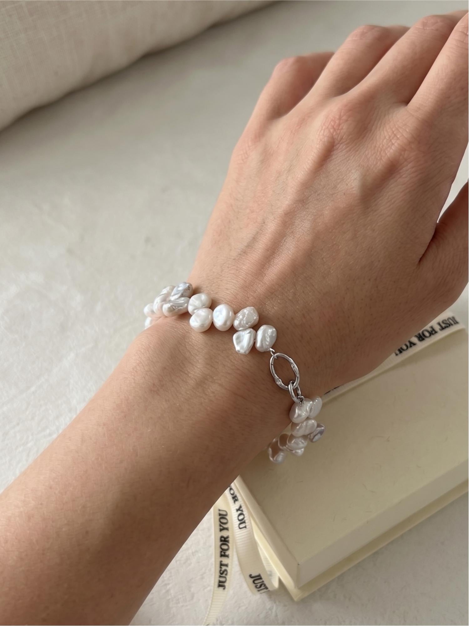 Model with tan skin wearing a Pearltide double-row Keshi pearl statement bracelet, showcasing elegant resort wear and clean girl aesthetic jewelry.
