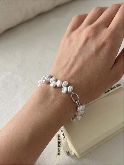 Model with tan skin wearing a Pearltide double-row Keshi pearl statement bracelet, showcasing elegant resort wear and clean girl aesthetic jewelry.