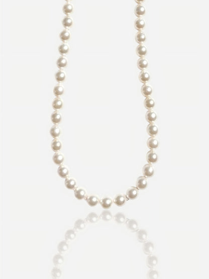 Close-up of Pearltide Eternal round pearl necklace with S925 sterling silver clasp on a white background with a soft reflection, luxury bridal jewelry.