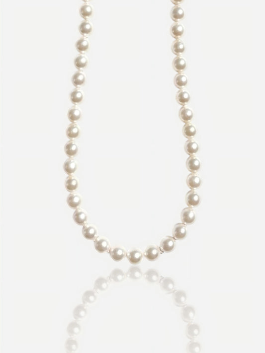Close-up of Pearltide Eternal round pearl necklace with S925 sterling silver clasp on a white background with a soft reflection, luxury bridal jewelry.