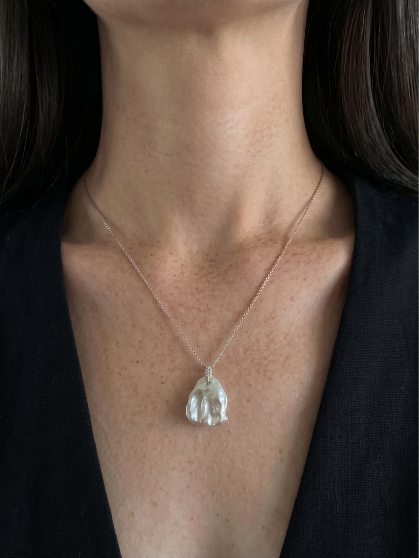 Pearltide minimalist petal baroque pearl necklace with pavé sparkle worn on tan skin, perfect for clean girl aesthetic and modern bridal jewelry.