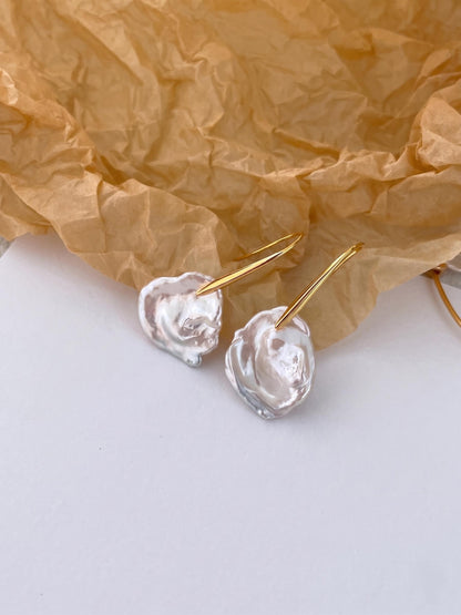 A pair of high-luster sculptural petal baroque pearl earrings with long 14K gold-filled hooks, elegant minimalist bridal accessories for modern weddings.