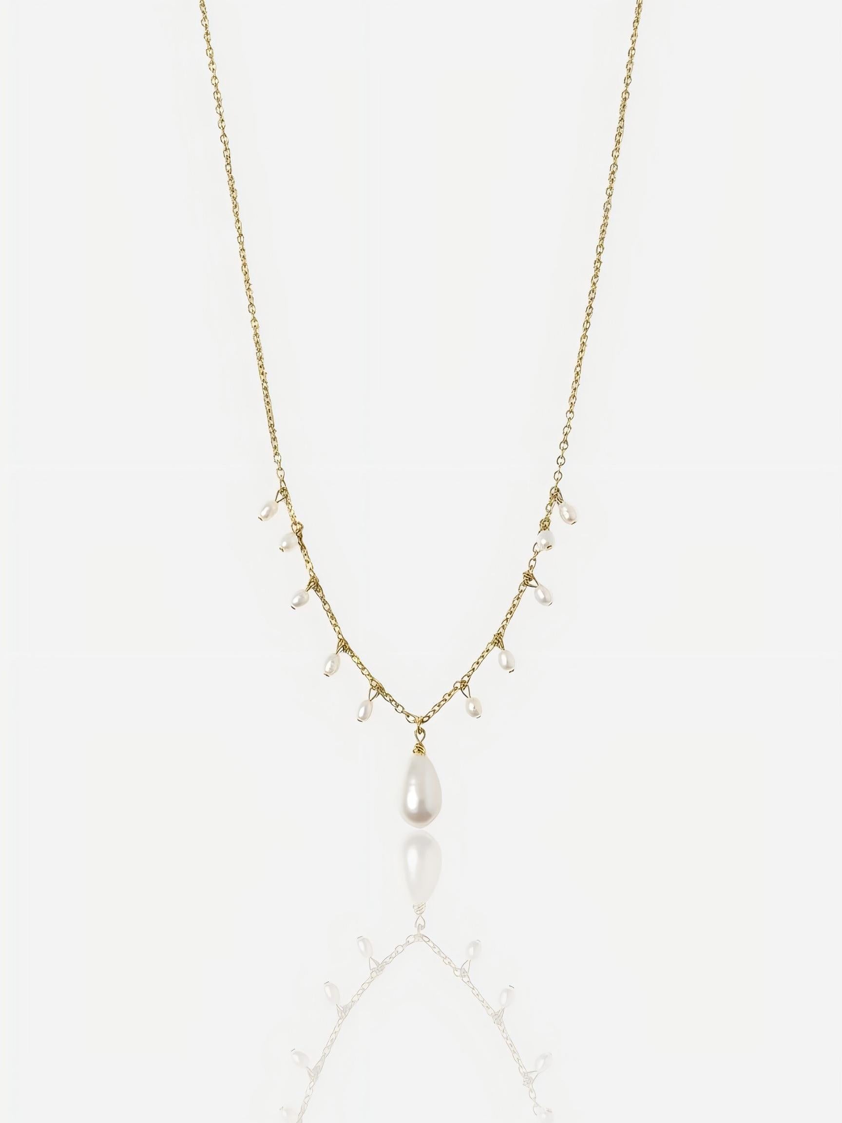 Close-up of Pearltide Moonlit Cascade necklace featuring multiple small rice pearls and a teardrop pendant on a 14K gold-filled chain, minimalist high-luster wedding jewelry.