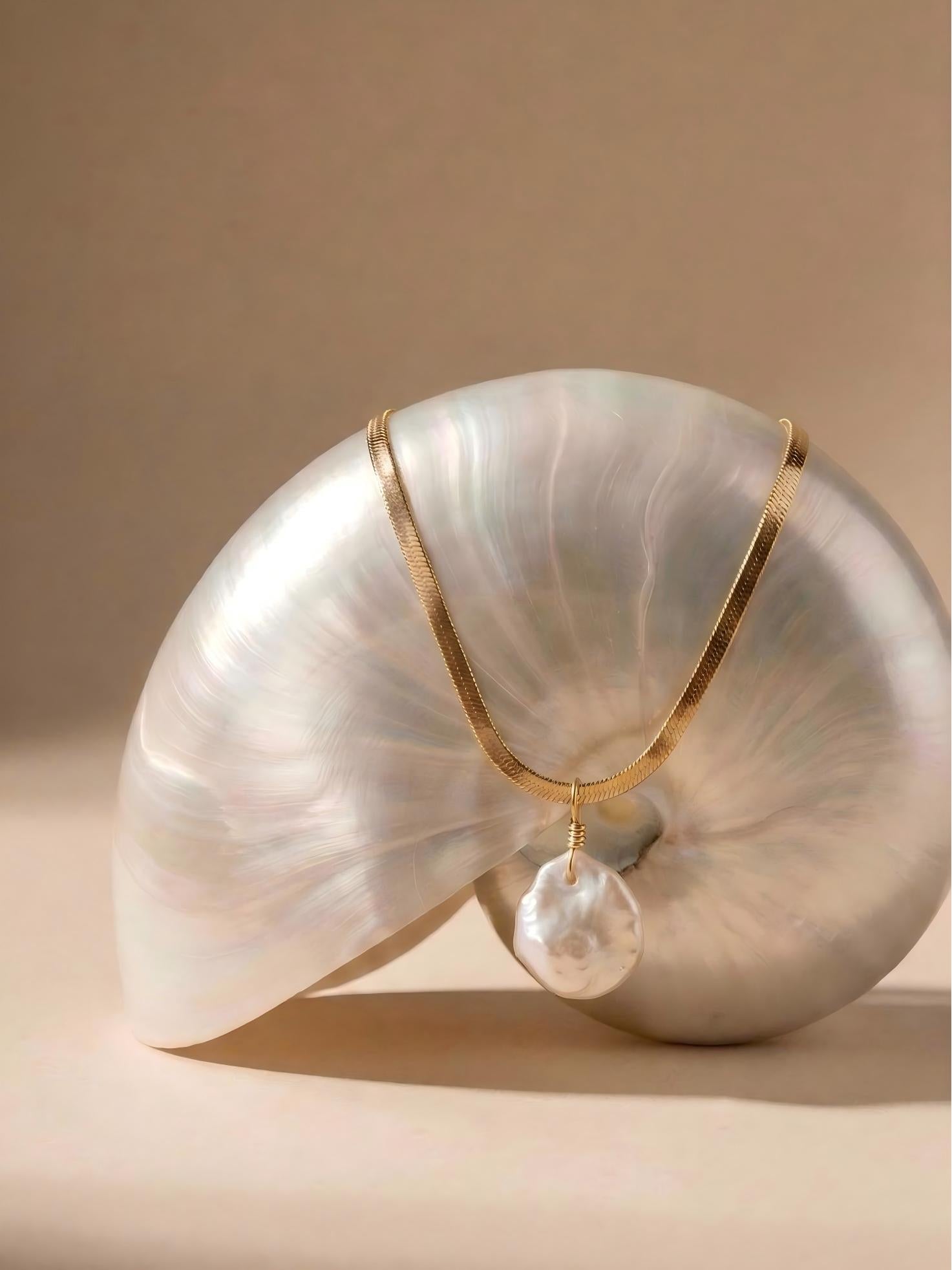 Natural irregular baroque pearl necklace draped over an iridescent seashell, aesthetic everyday jewelry