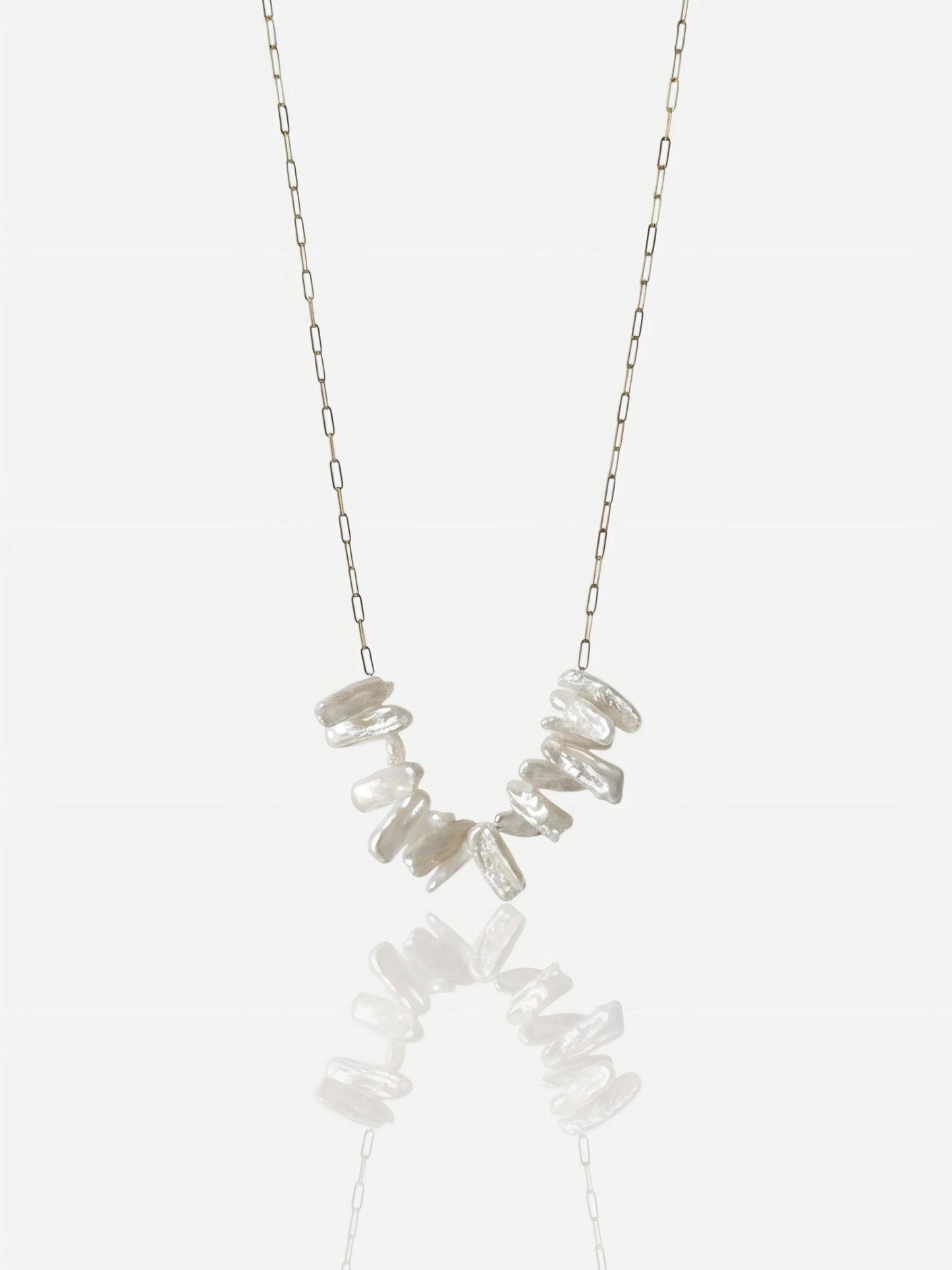 Close-up of Pearltide Lyra necklace featuring high-luster irregular stick pearls on a dainty gold paperclip chain, minimalist organic jewelry on a white background.
