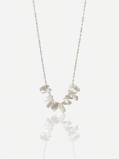 Close-up of Pearltide Lyra necklace featuring high-luster irregular stick pearls on a dainty gold paperclip chain, minimalist organic jewelry on a white background.