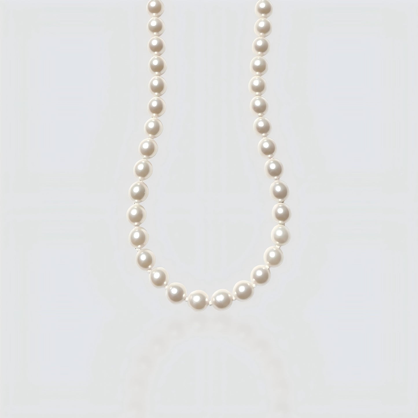 Studio shot of a large, metallic-luster Edison baroque pearl necklace on a neutral grey background.