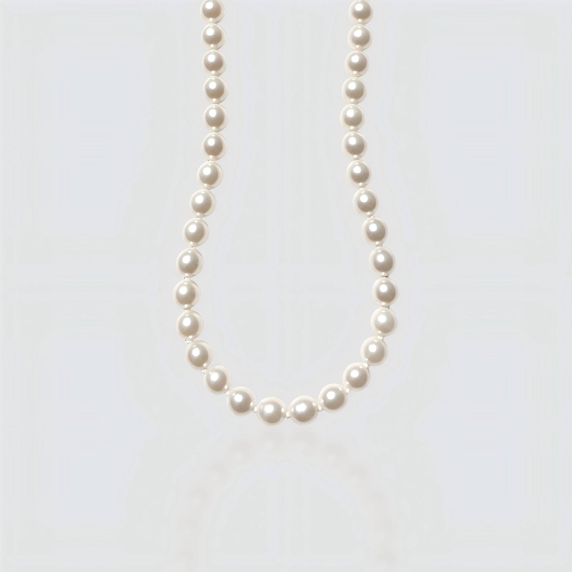 Studio shot of a large, metallic-luster Edison baroque pearl necklace on a neutral grey background.