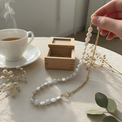 Macro detail shot showing the connection point where the flat coin pearls meet the gold chain via a circular gold ring.