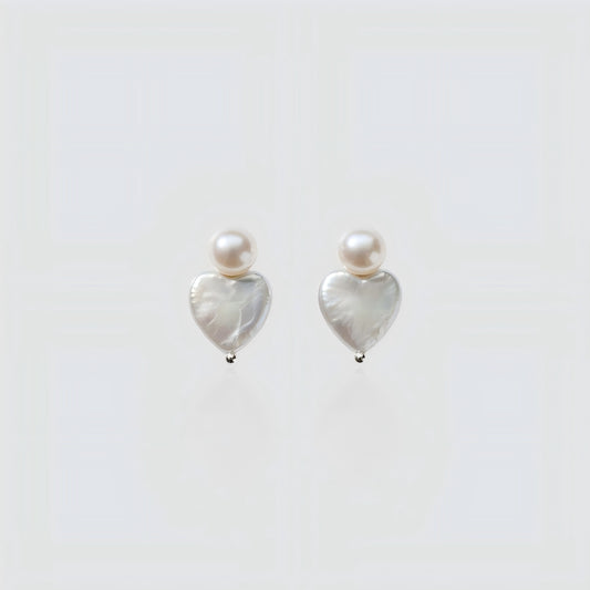 Pure Elegance. A detailed view of the Pearltide Heart Pearl Studs against a pristine background, highlighting the organic texture and creamy luster of the baroque pearls.