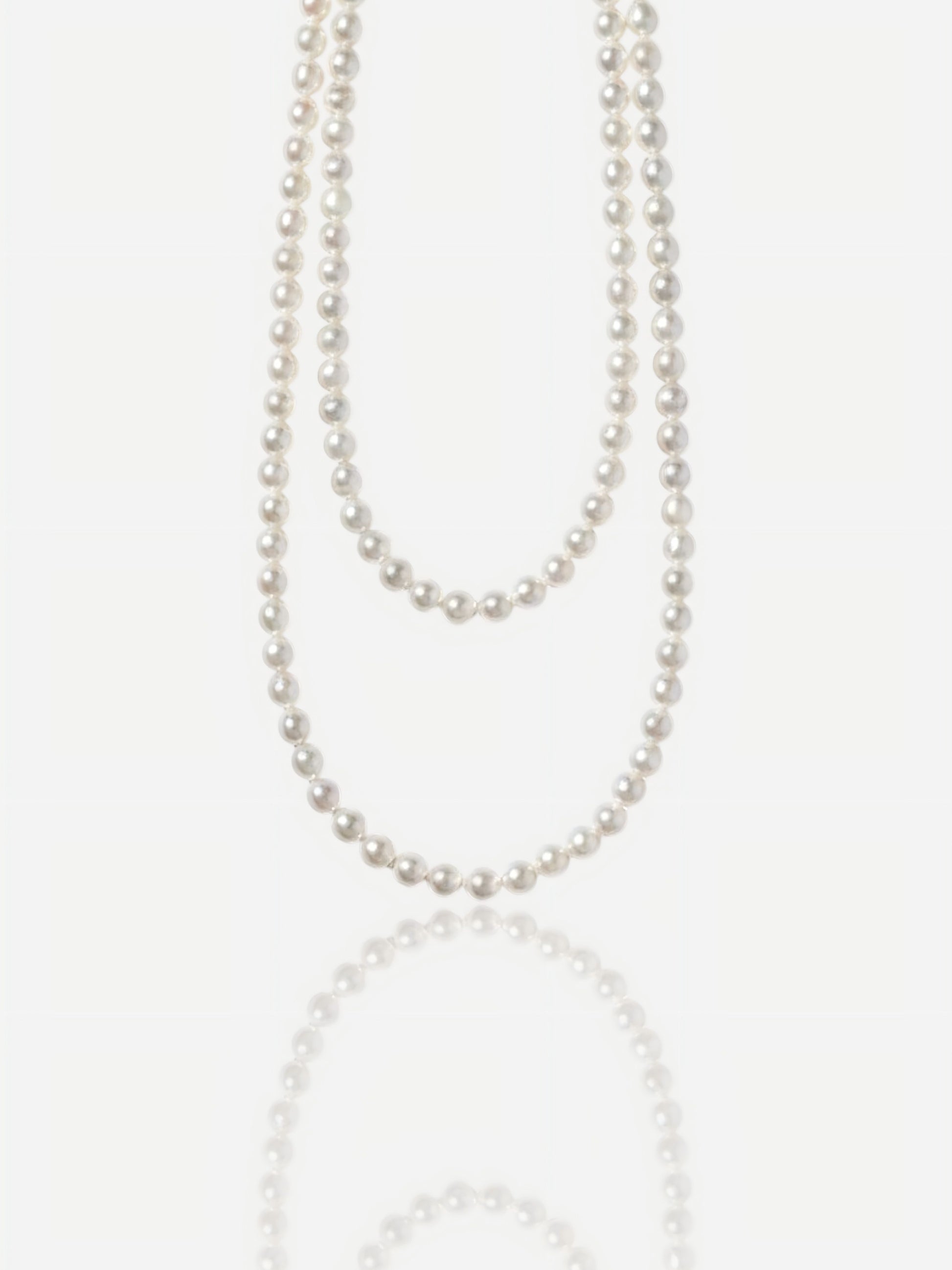Close-up of Pearltide Eternal round pearl jewelry necklace with S925 sterling silver clasp on a white background, high-luster classic pearl jewelry for weddings.