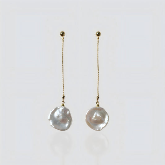 A pair of elegant gold chain drop earrings with irregular freshwater baroque pearls, presented on a soft grey background for clear product viewing.
