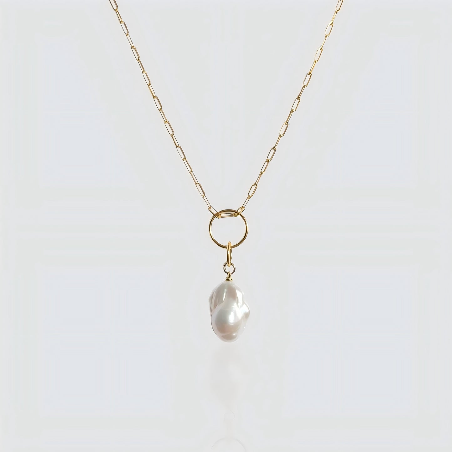 A striking balance between a statement baroque pearl and contemporary paperclip link chain.