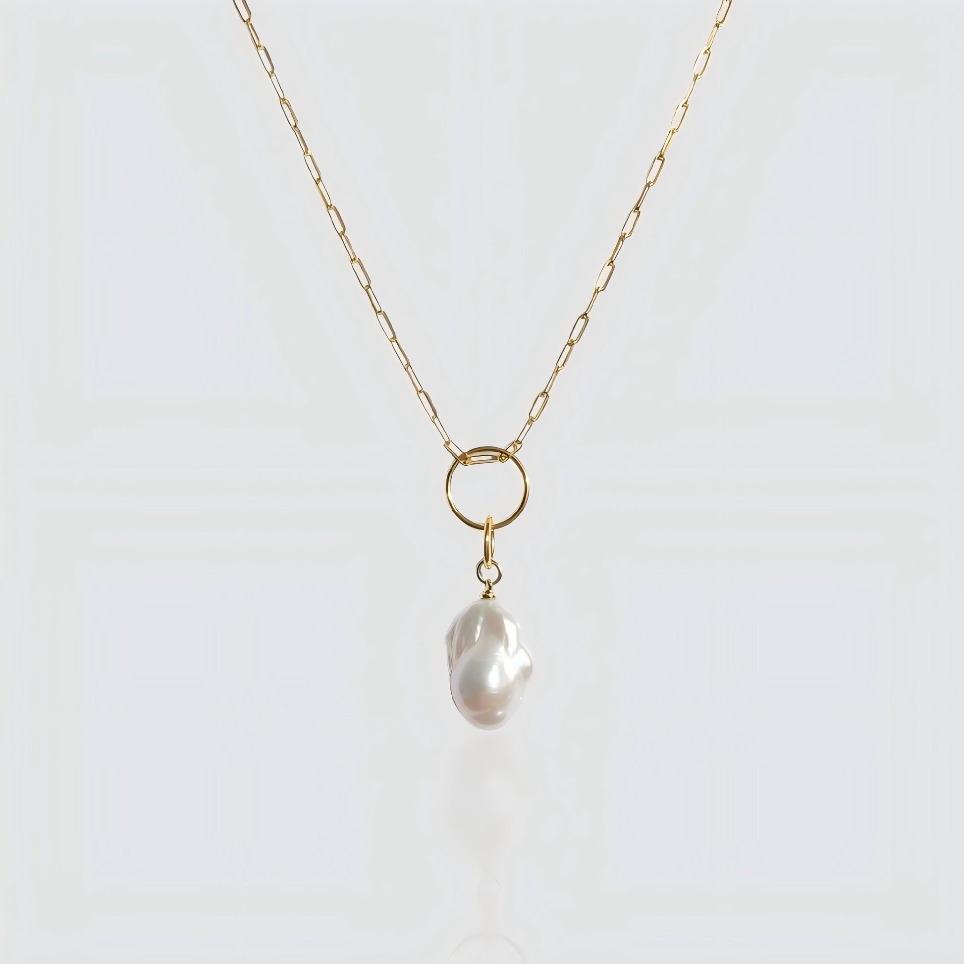 A striking balance between a statement baroque pearl and contemporary paperclip link chain.