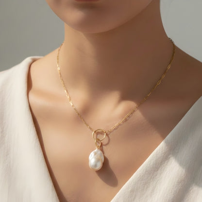 A striking balance between a statement baroque pearl and contemporary paperclip link chain.