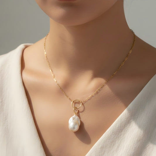 A striking balance between a statement baroque pearl and contemporary paperclip link chain.