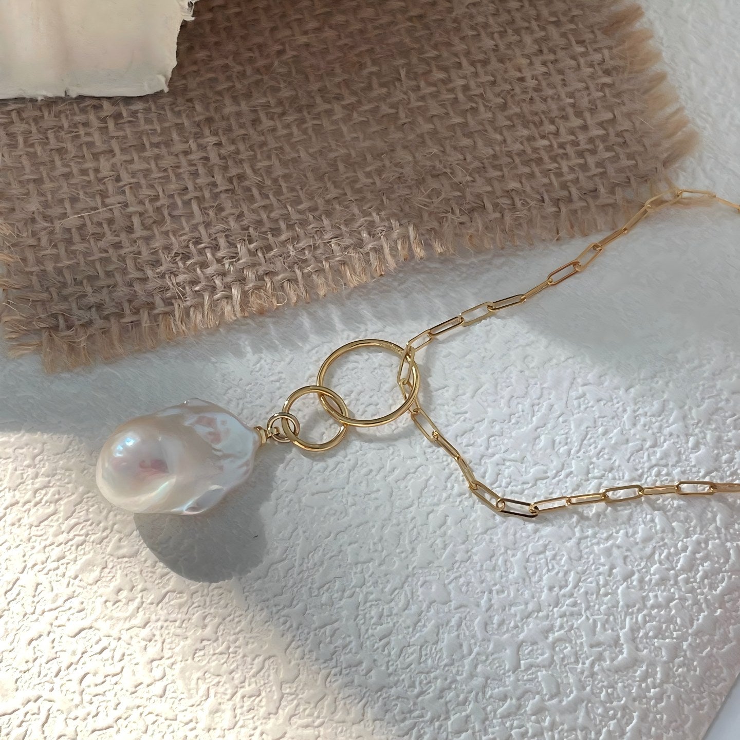 See how the oversized pearl adds a luminous focal point to any ensemble, from silk blouses to casual knits