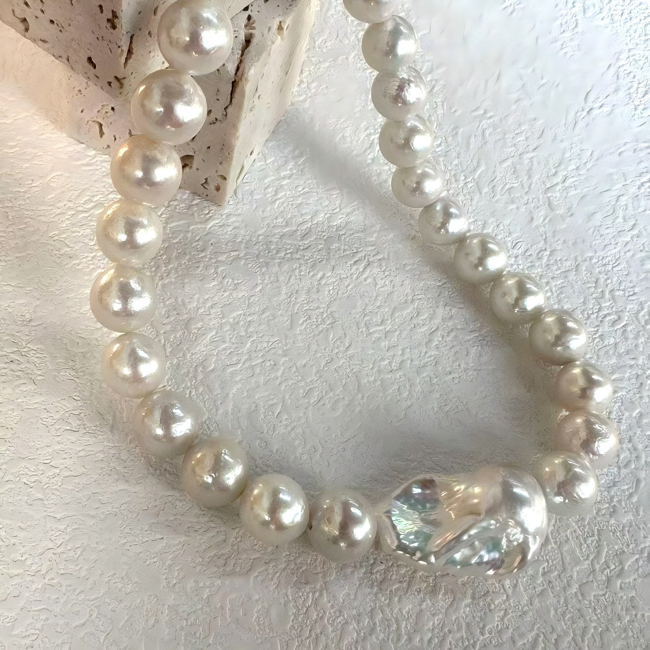 Extreme close-up macro shot focusing on the colossal central Edison pearl, revealing its intense metallic luster and unique organic rippled surface.