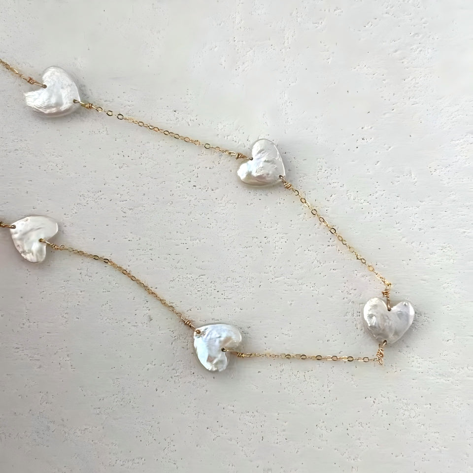 Close-up macro shot of a single baroque heart pearl showing the wire-wrapping detail and pearlescent luster.