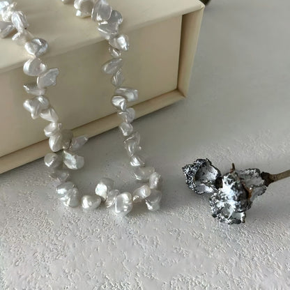 Extreme close-up showing the thick nacre and irregular, folded surface texture of the Keshi pearls.