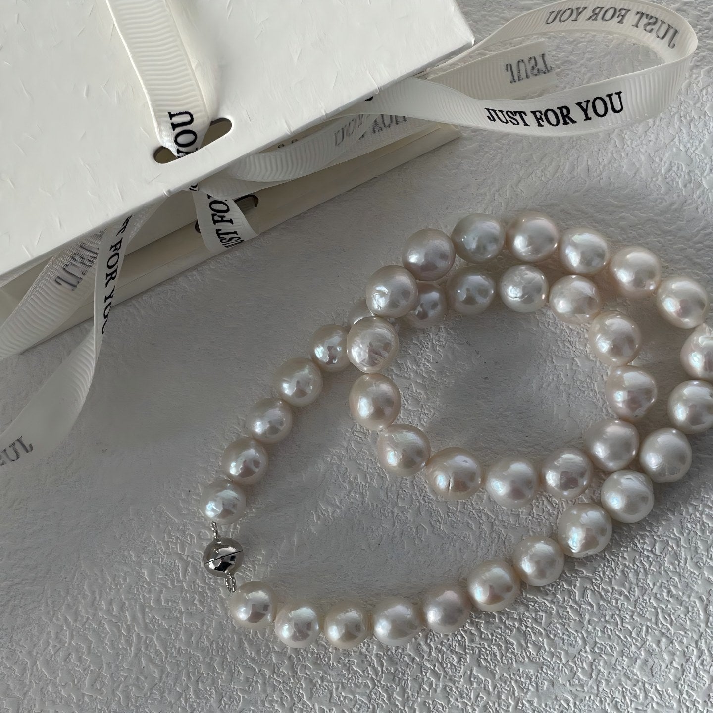 Extreme close-up showing the characteristic rippled texture and rainbow orient of a genuine Edison pearl.