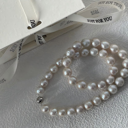 Extreme close-up showing the characteristic rippled texture and rainbow orient of a genuine Edison pearl.